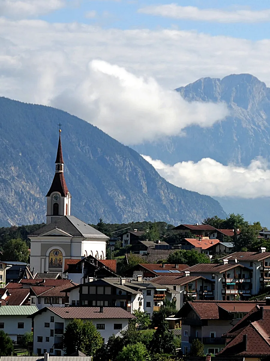 A village church spire below the Alps in Tyrol, Austria